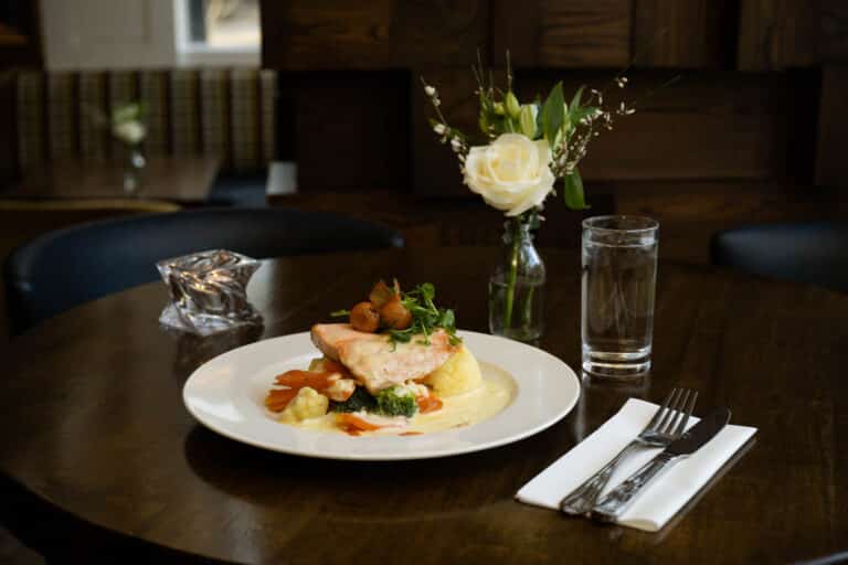 Chicken Dish on high table with glass of water