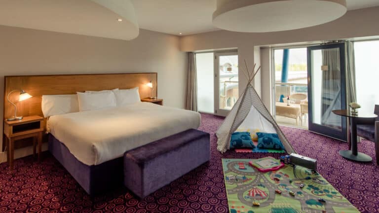 Spacious Family Bedroom with a table of milk and cookies and in the background, tipis at Osprey Hotel Naas